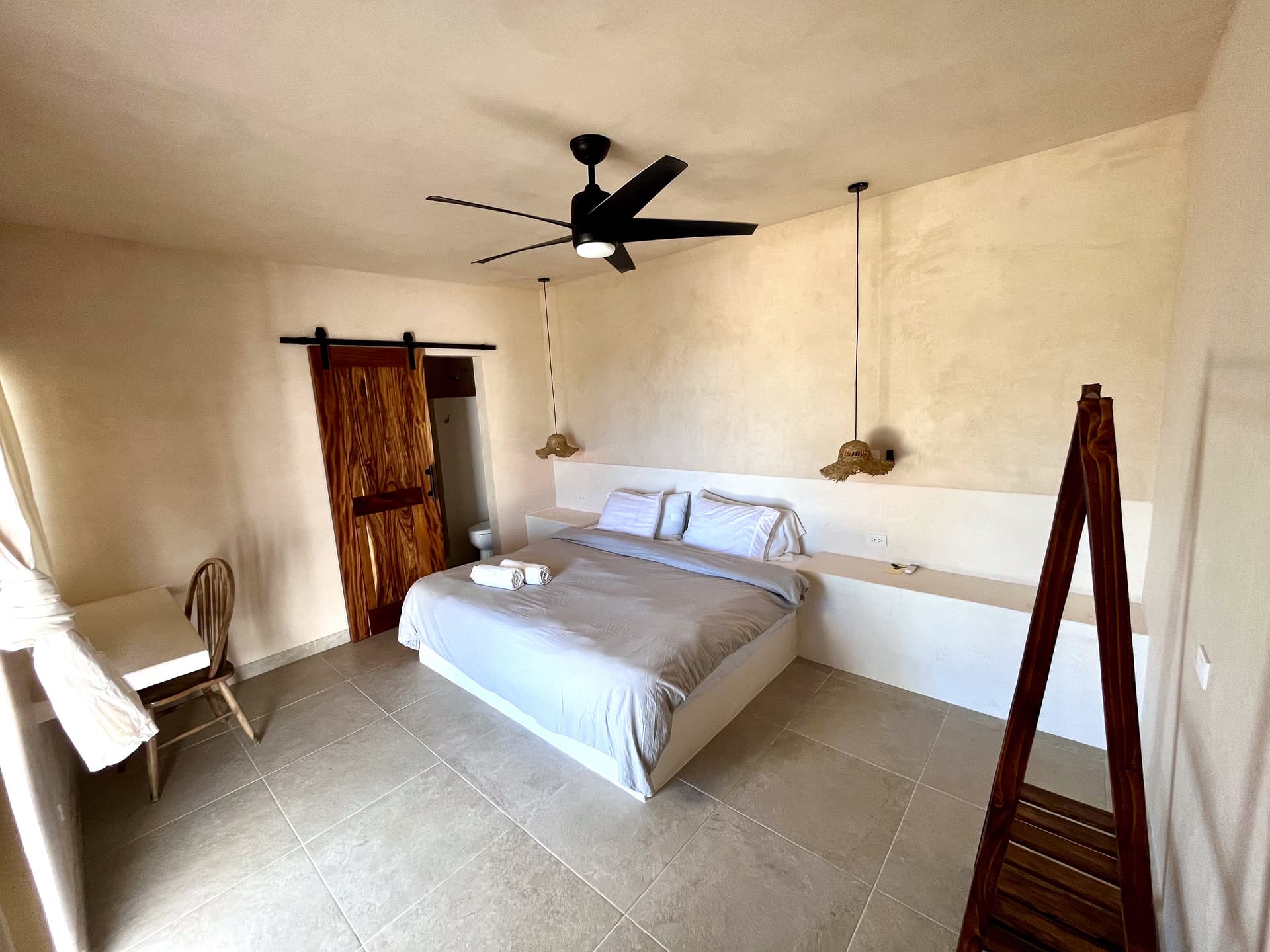 Spacious private room at La Ventana Hostel with king-size bed and sliding barn door