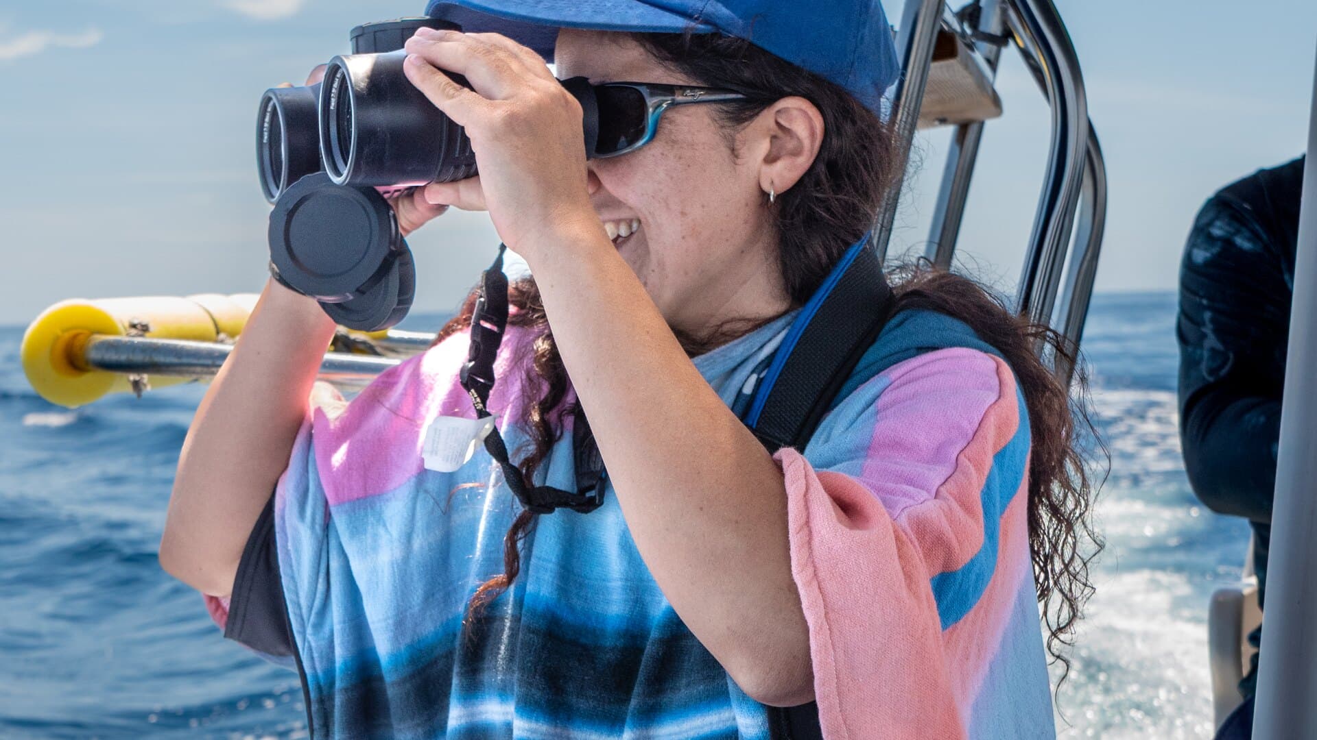 A guest using binoculars aboard a panga