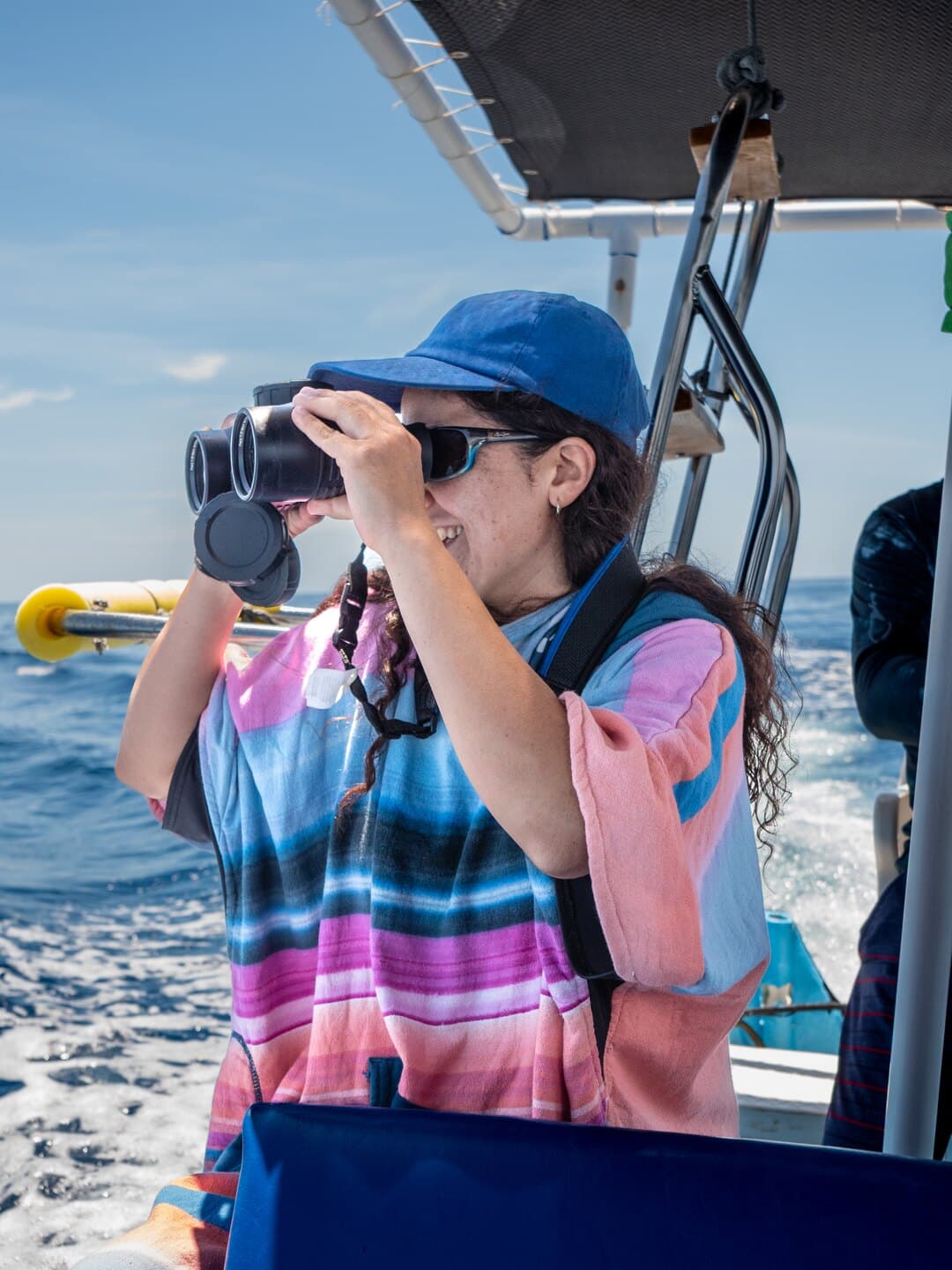 A guest using binoculars aboard a panga