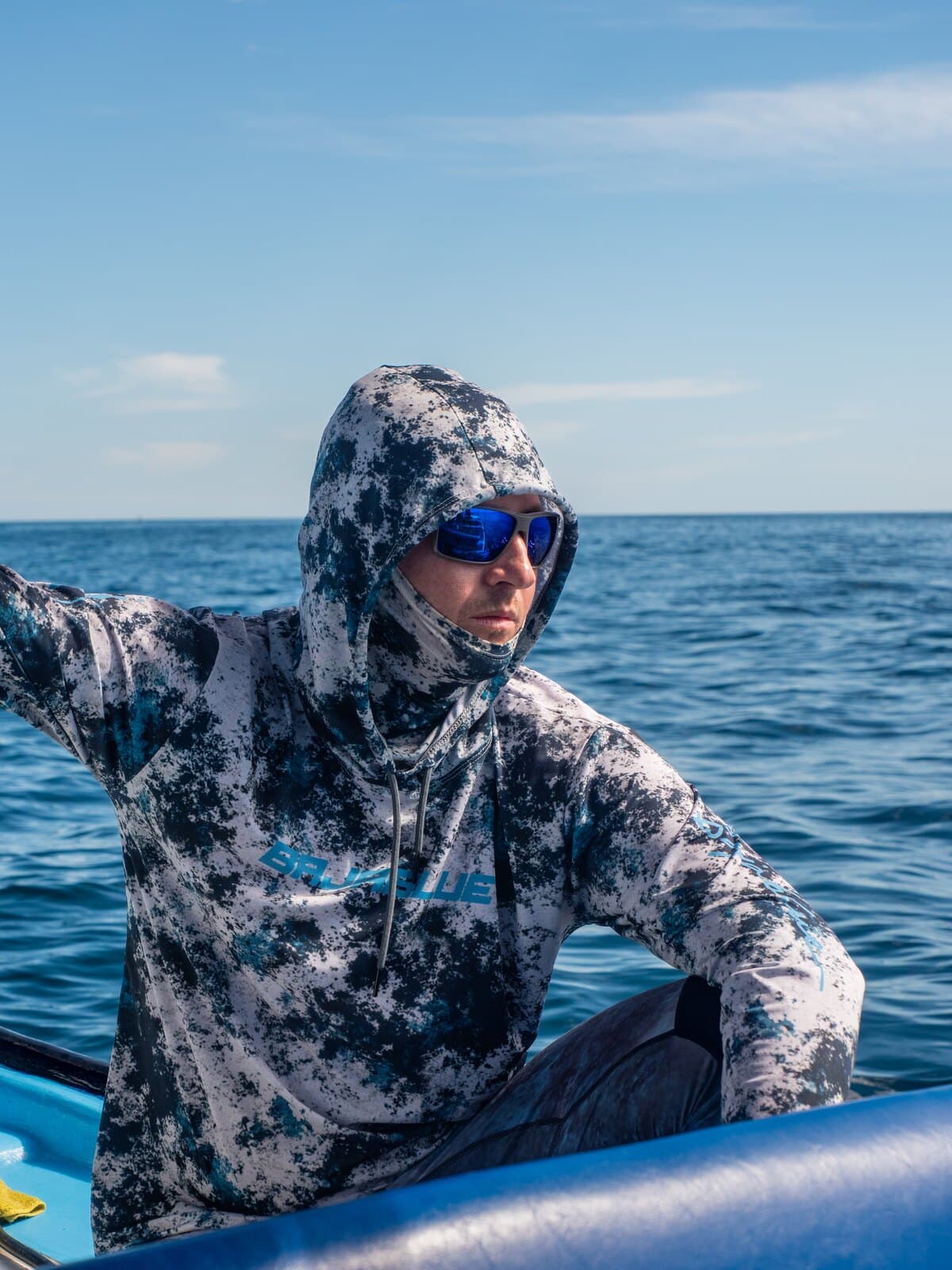 A person in a blue patterned hoodie aboard a boat at sea