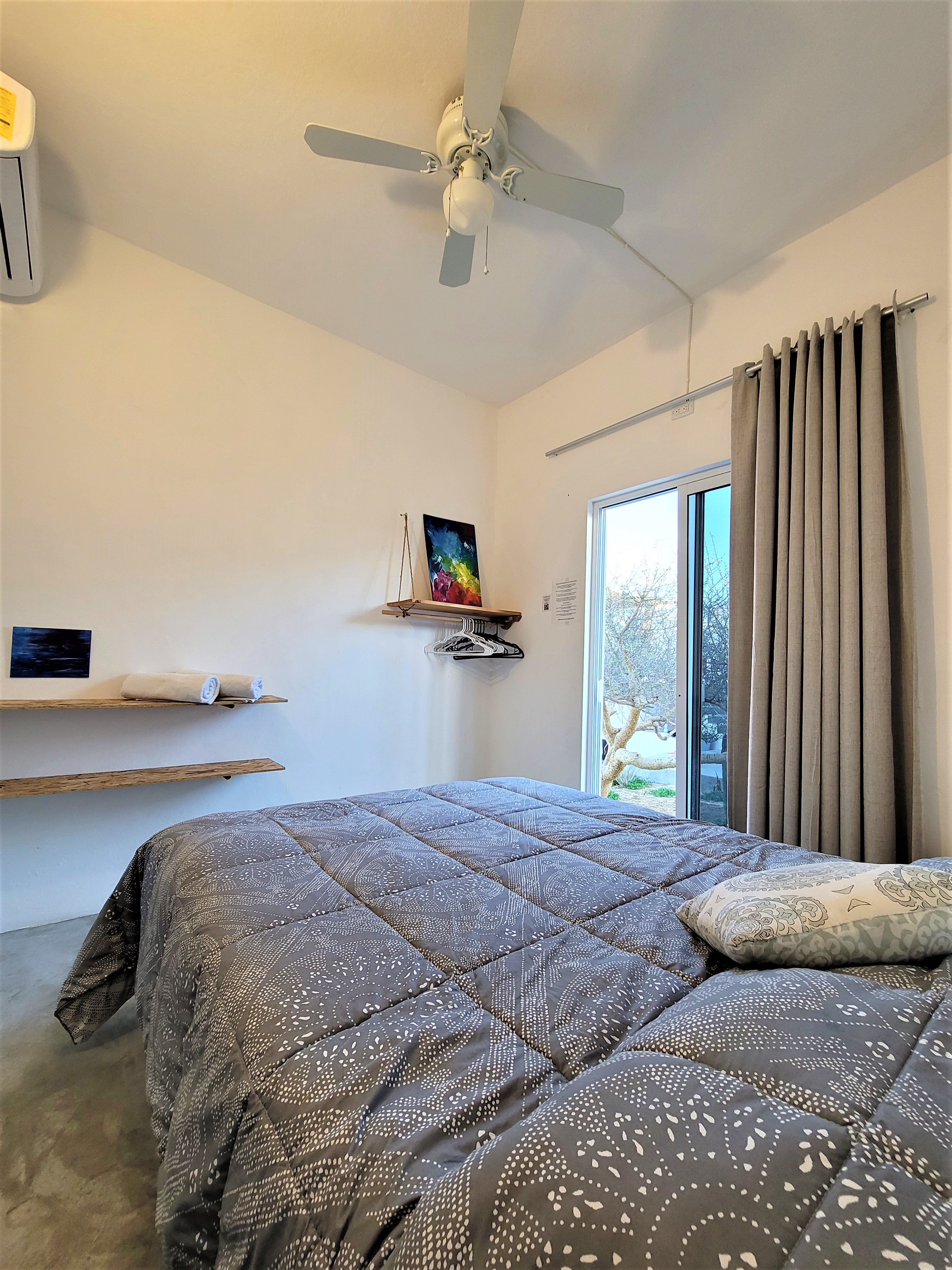 Private room at La Ventana Hostel with ceiling fan, en-suite bathroom, and natural light