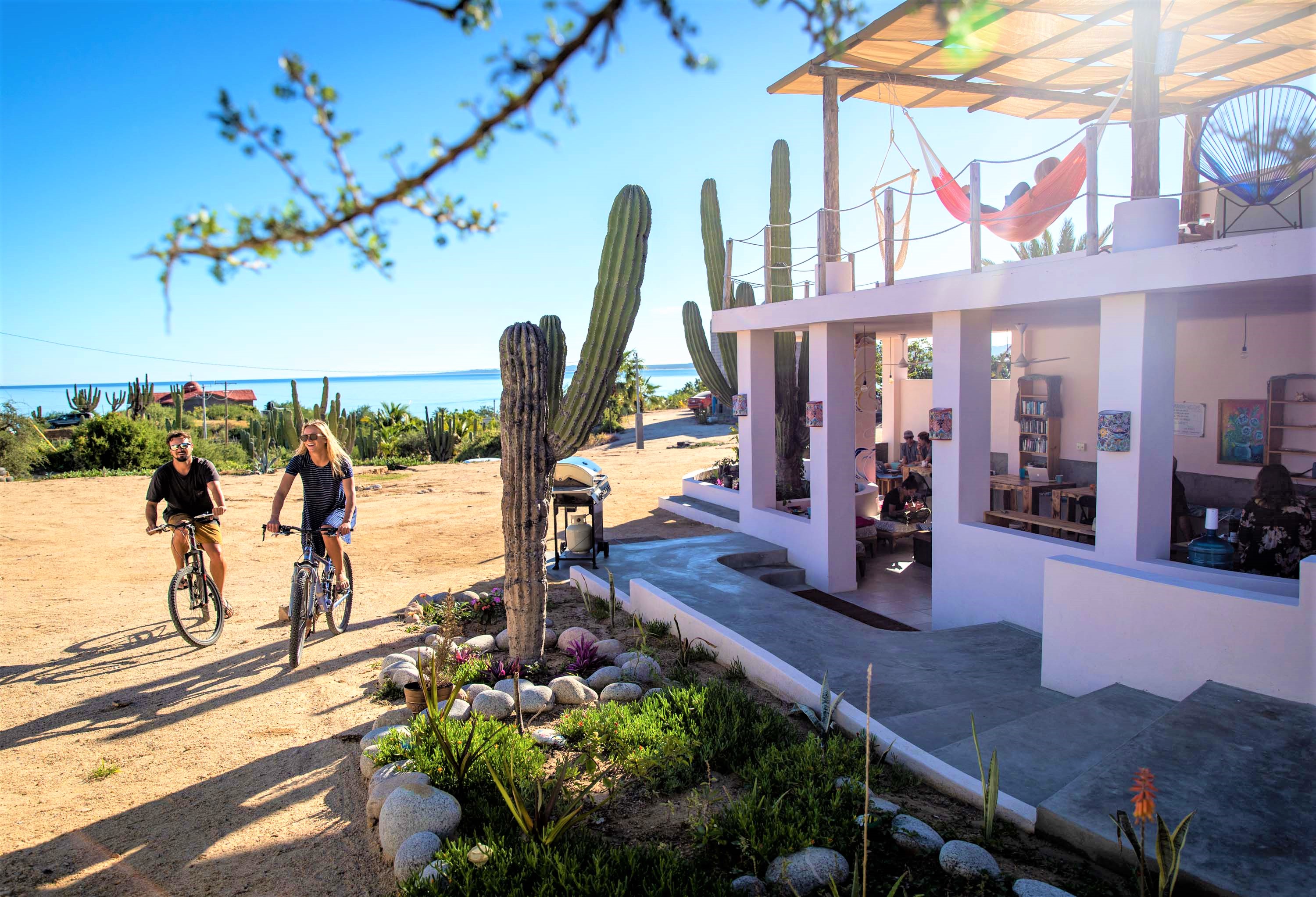 Guests biking outside La Ventana Hostel — bikes available for exploring the village