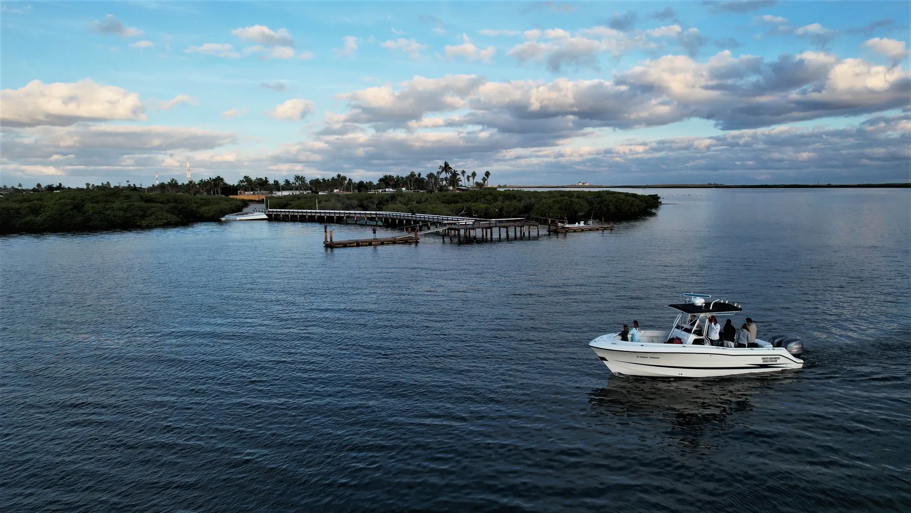 A panga approaching a dock across calm water