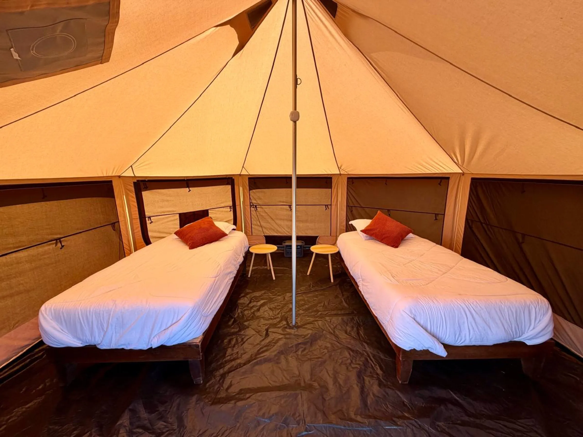 Inside a canvas glamping tent with two single beds